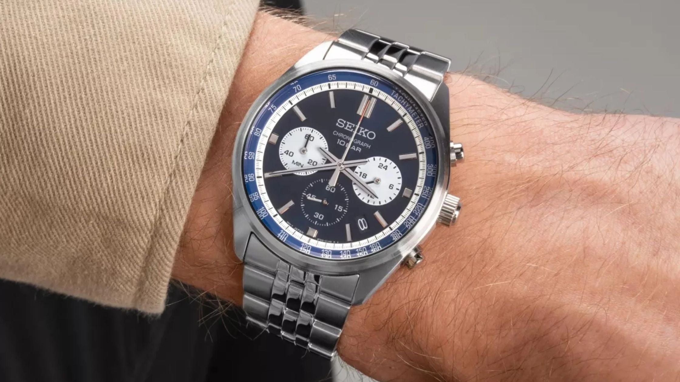 Seiko chronograph watch with a blue dial and stainless steel bracelet worn on the wrist.