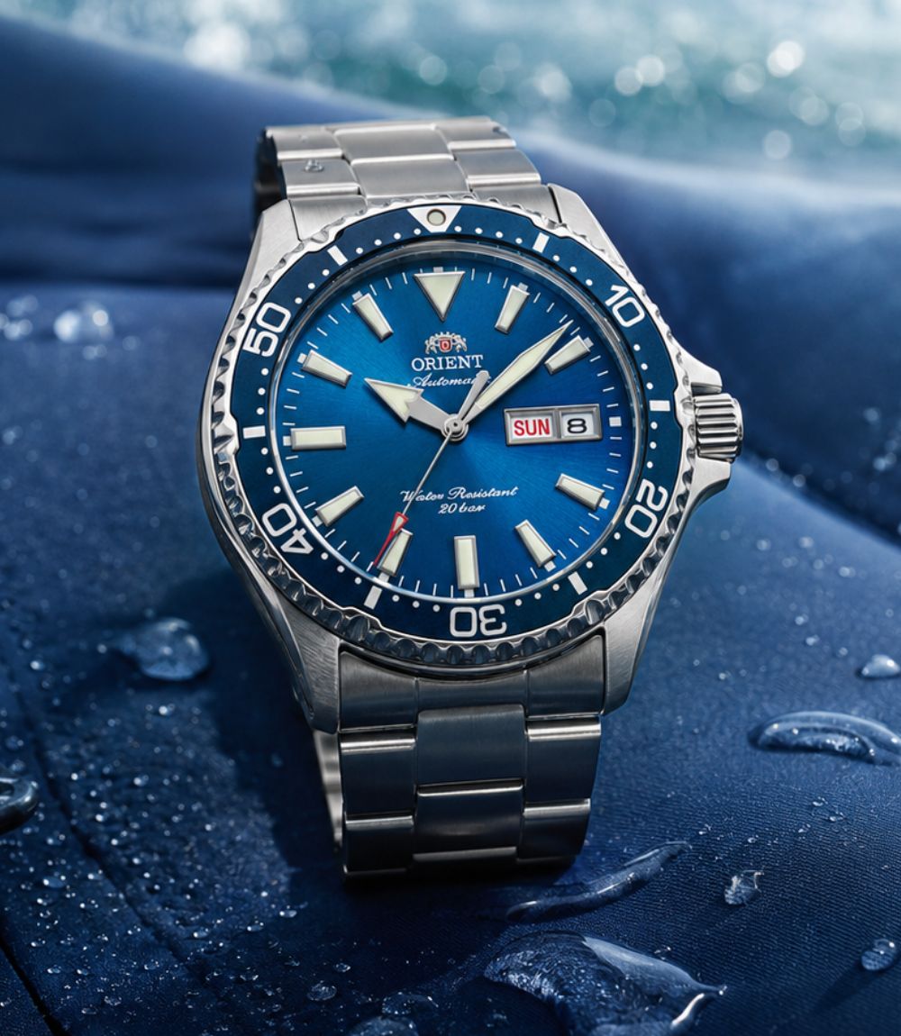Orient Kamasu sports mens watch featuring a vibrant blue sunburst dial, day-date window, blue bezel, and stainless steel bracelet