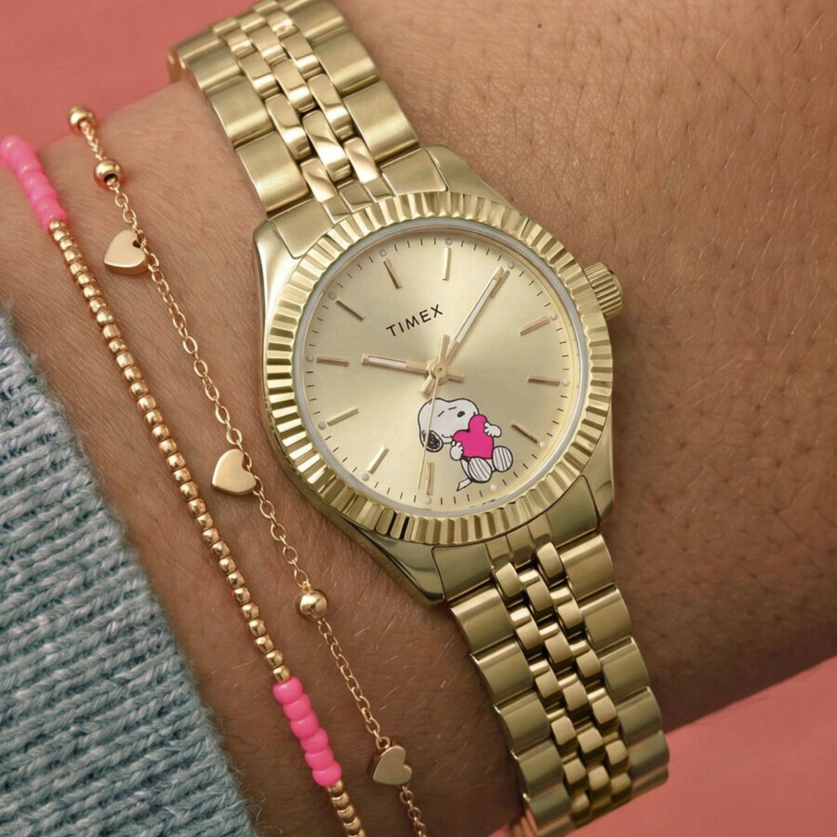 Peanuts X Timex Legacy TW6A07400 wrist view showing gold dial quartz watch styled on a person wearing a yellow gold-tone steel bracelet