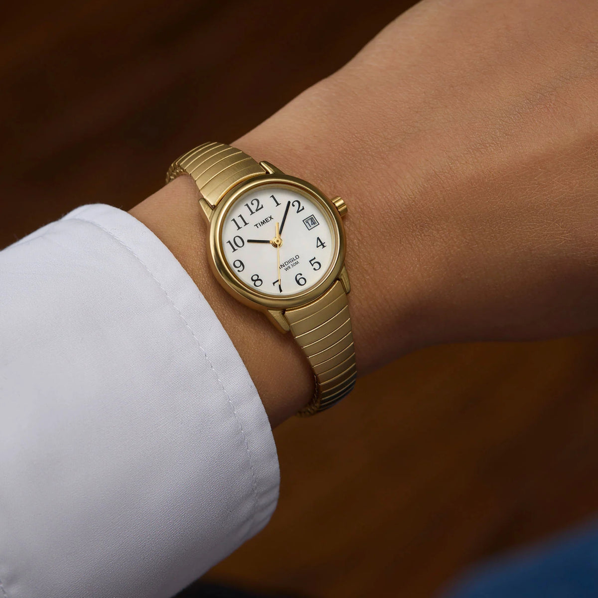 Timex Easy Reader T2H351 wrist view showing a white dial ladies watch styled on a person wearing a yellow gold-tone steel expansion band