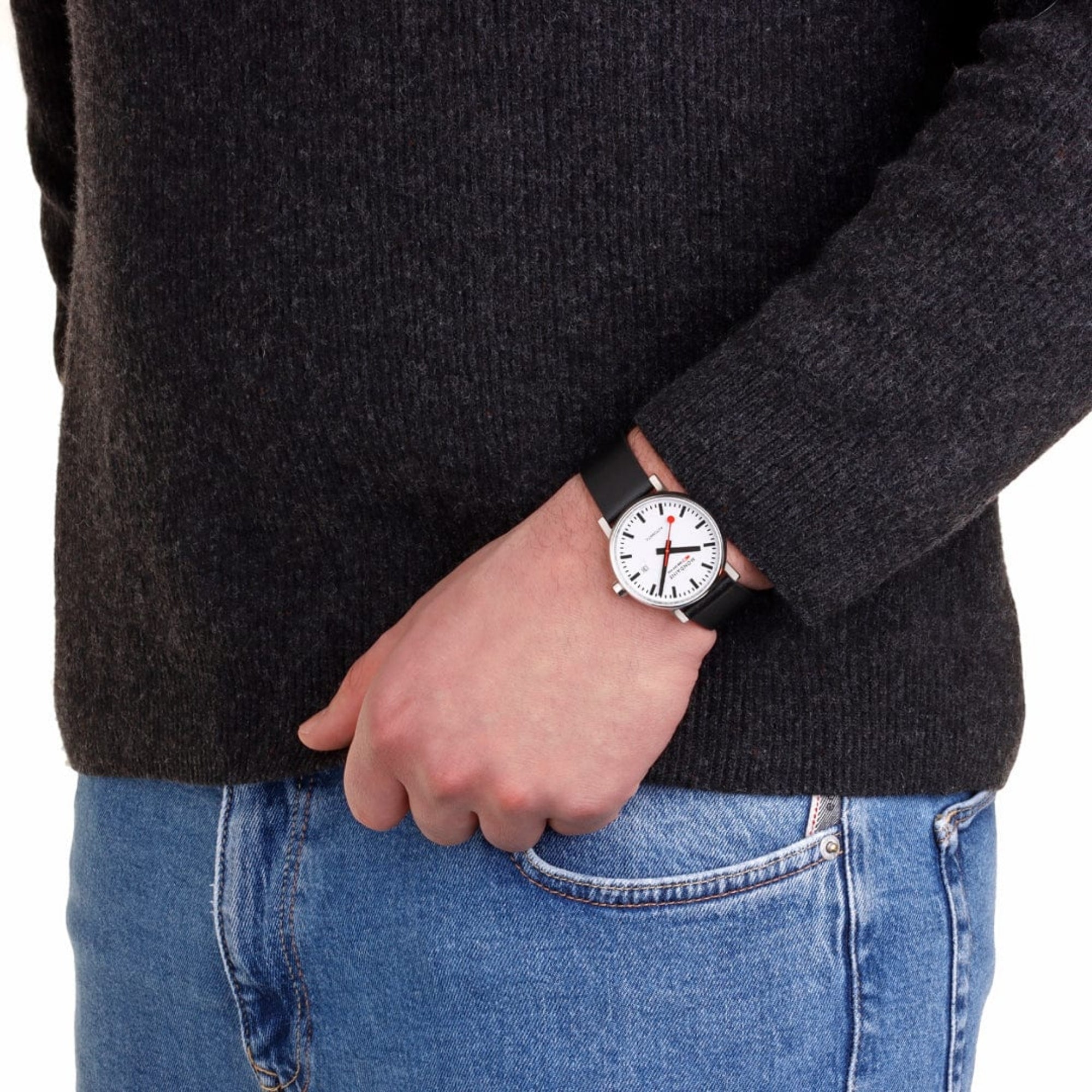 Men’s wristwatch with white dial and black leather strap worn on a hand