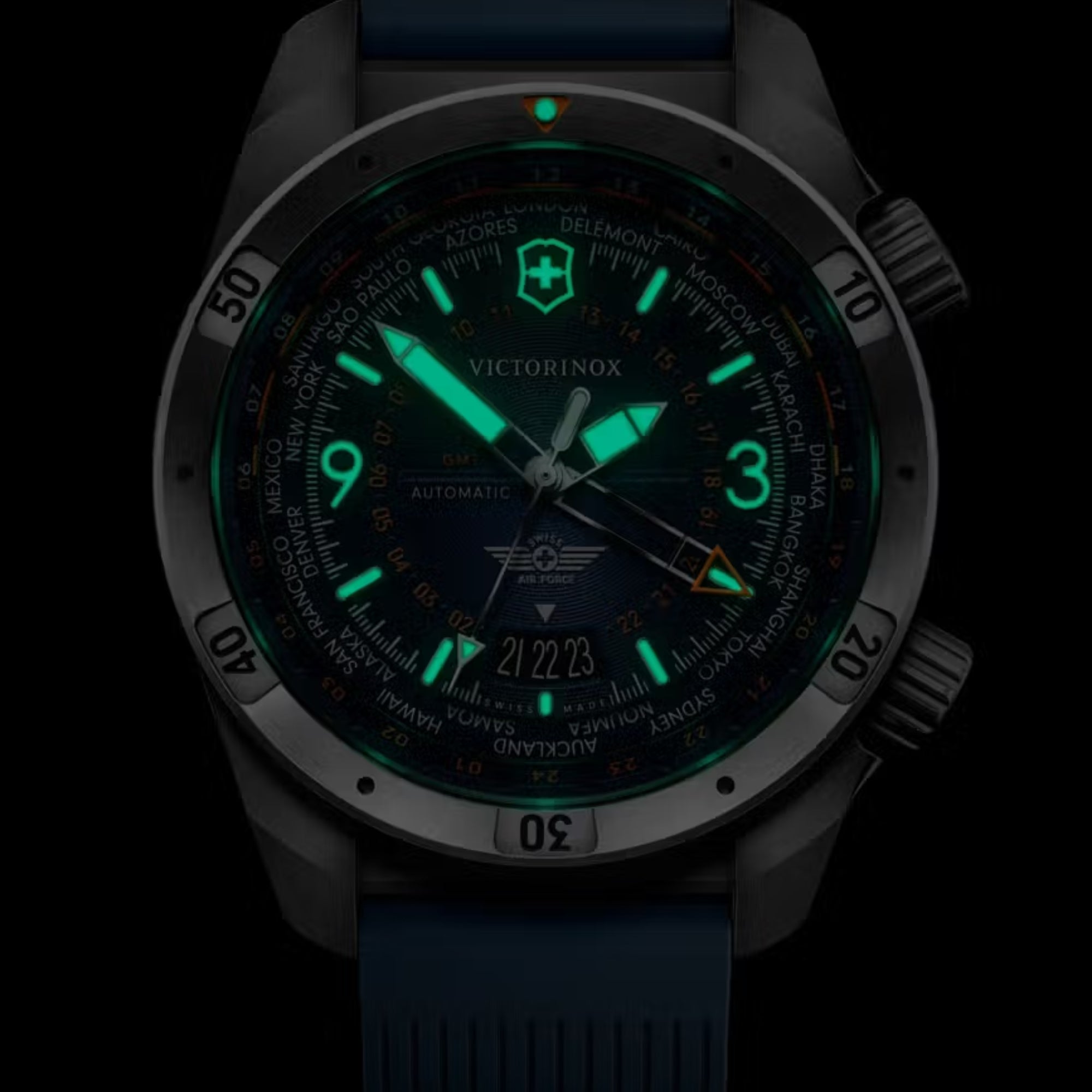 Close-up of Victorinox Air Pro 242003 blue dial in darkness highlighting intense green lume and GMT function