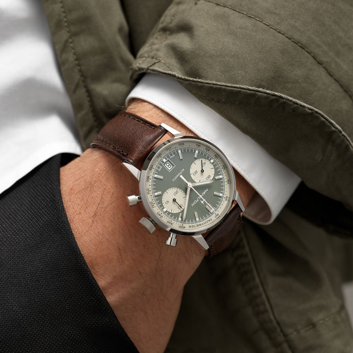 Men's Hamilton chronograph watch on wrist, green dial and brown leather strap