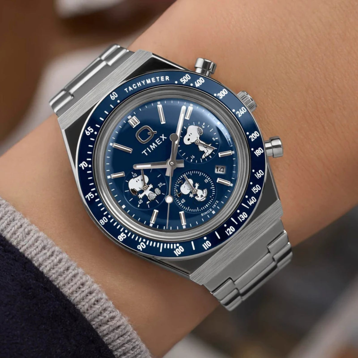 Timex Peanuts TW2Y45300 wrist view showing blue dial chronograph styled on a person wearing a steel bracelet