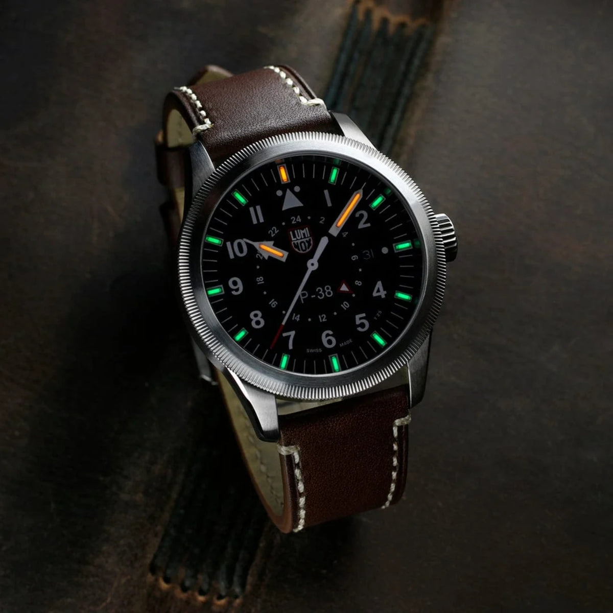 Luminox P-38 Lightning Air Pilot 9520 Series XA.9521 black dial mens watch lifestyle view showcasing illuminated dial markers on dark surface
