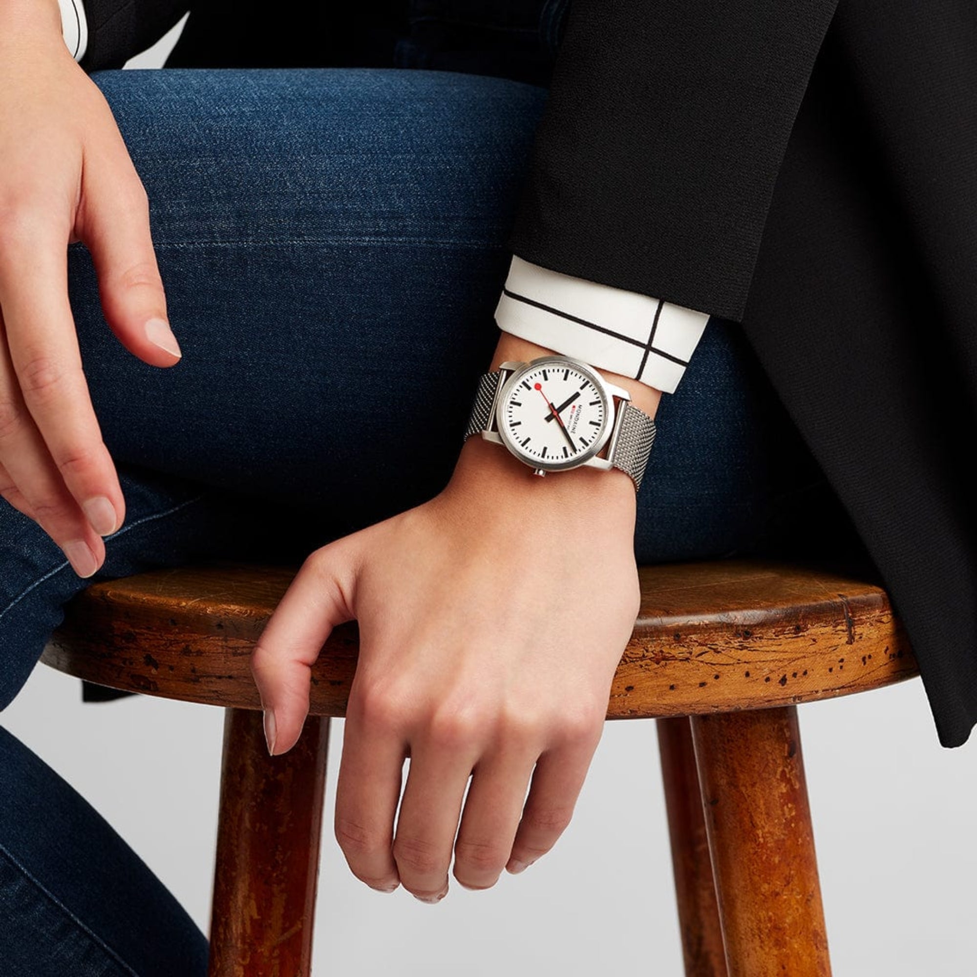 Mondaine Simply Elegant A400.30351.16SBZ analog wristwatch styled on a female wrist paired with a dark blazer