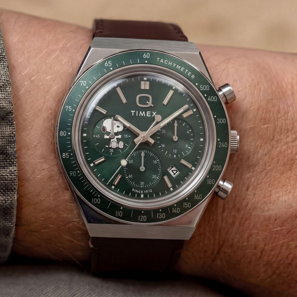 Timex Peanuts x Q Timex TW6A04400 wrist view showing green dial chronograph watch styled on a person wearing a leather strap