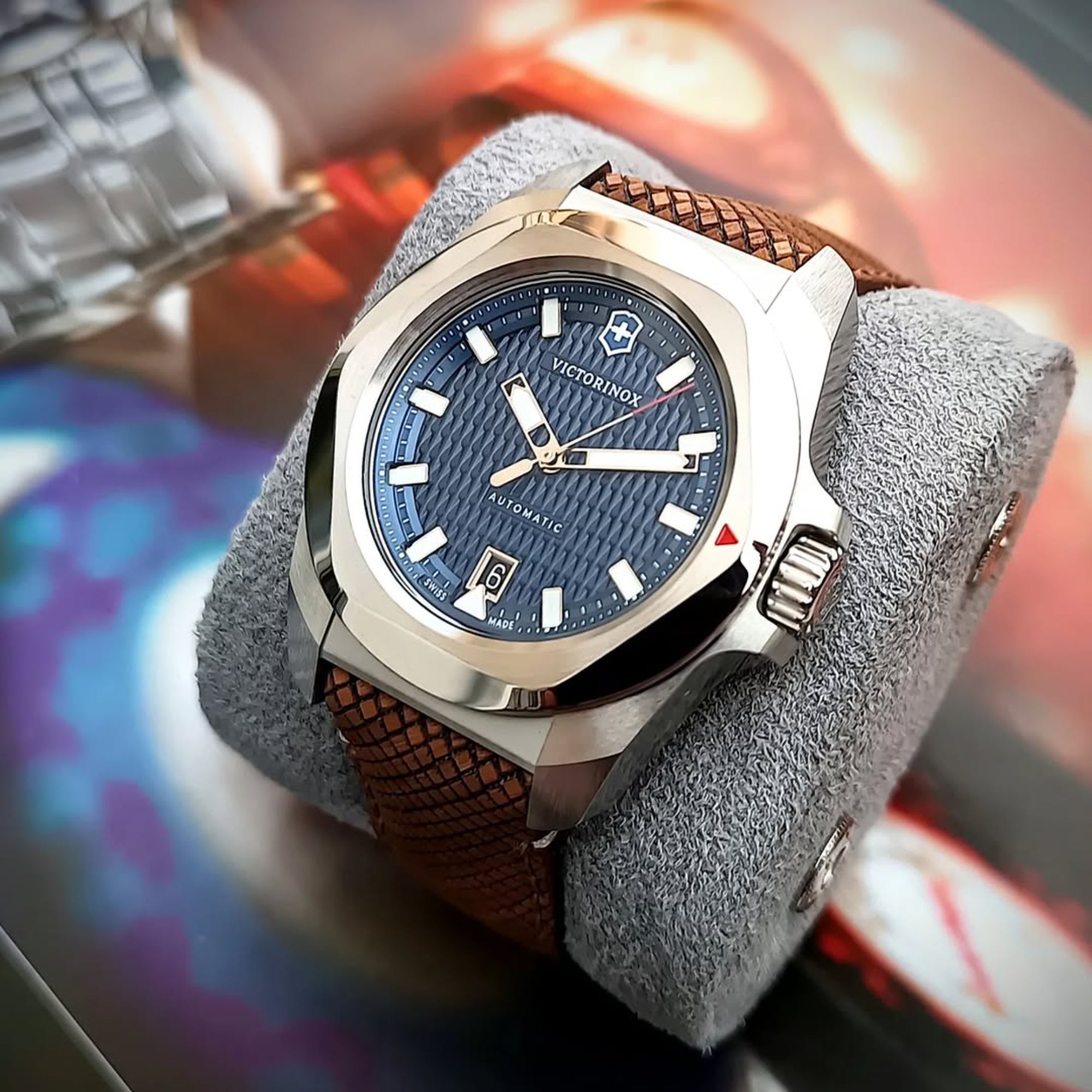 Victorinox I.N.O.X. 41mm Automatic blue dial wood strap watch 242018.1 resting on a gray display cushion