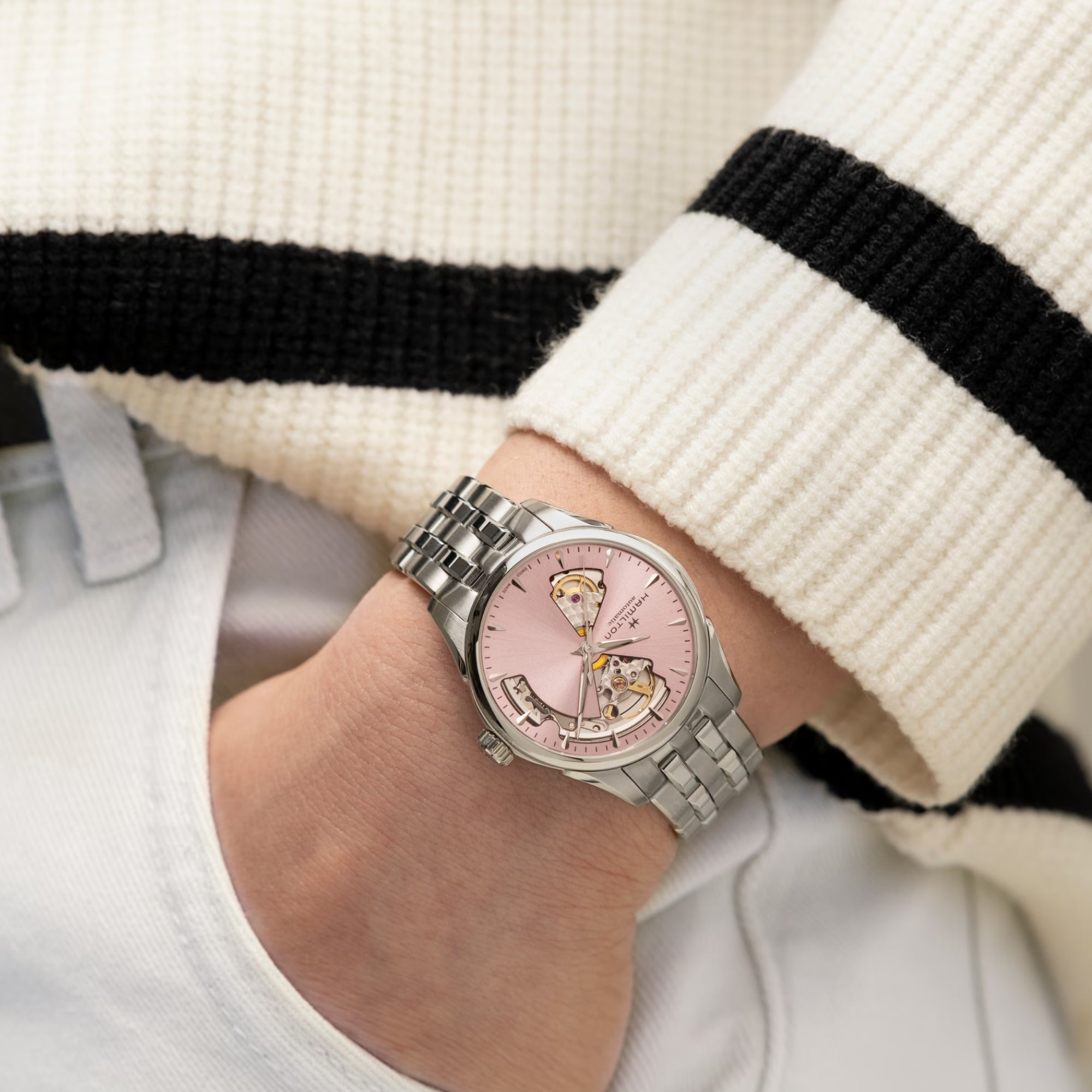 Hamilton Jazzmaster watch on wrist, pink dial with open-heart movement, steel bracelet