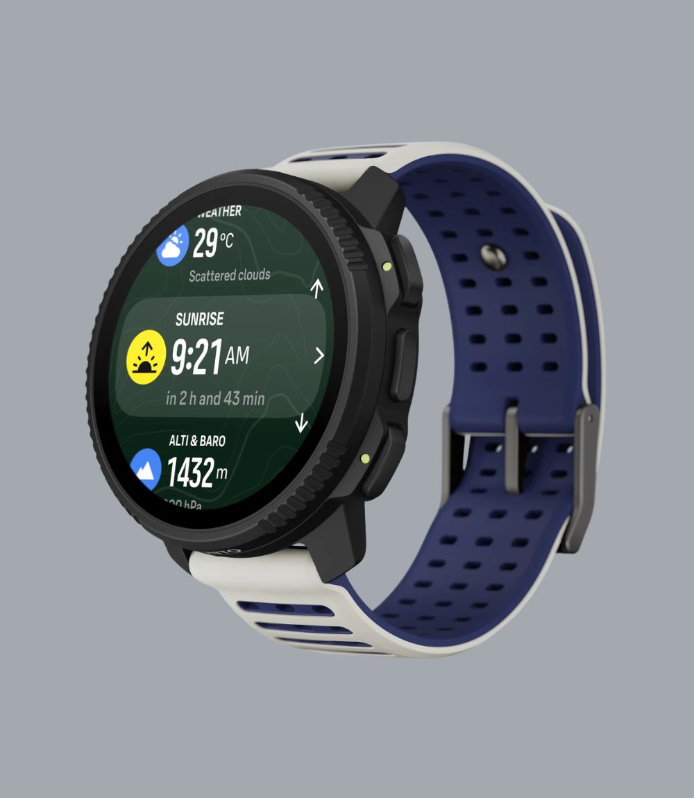 A Suunto smartwatch with a round black bezel and a dual-color strap featuring a navy blue perforated upper section and a white lower section, shown on a solid gray background.