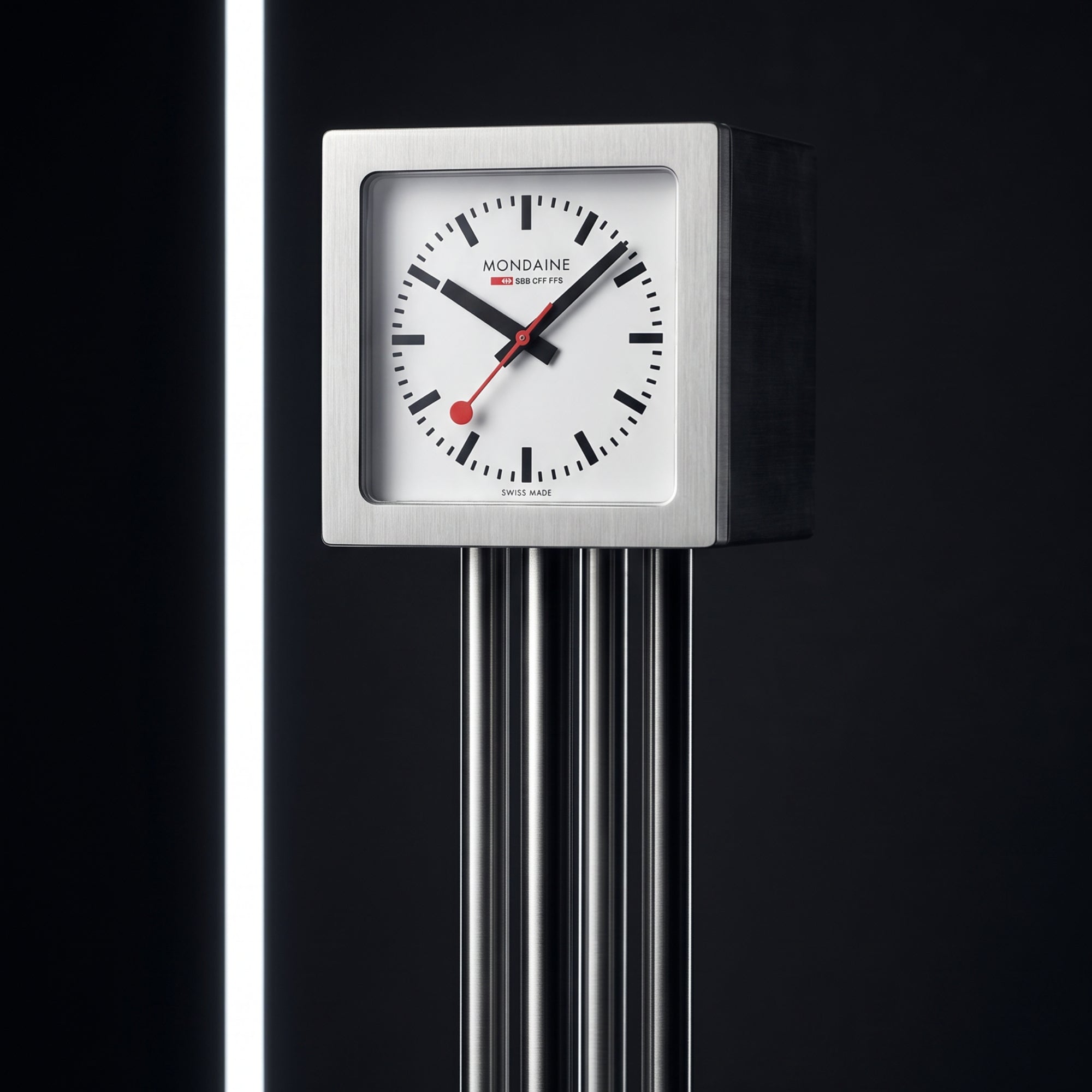 Square aluminum table clock with white dial, black markers, and red second hand
