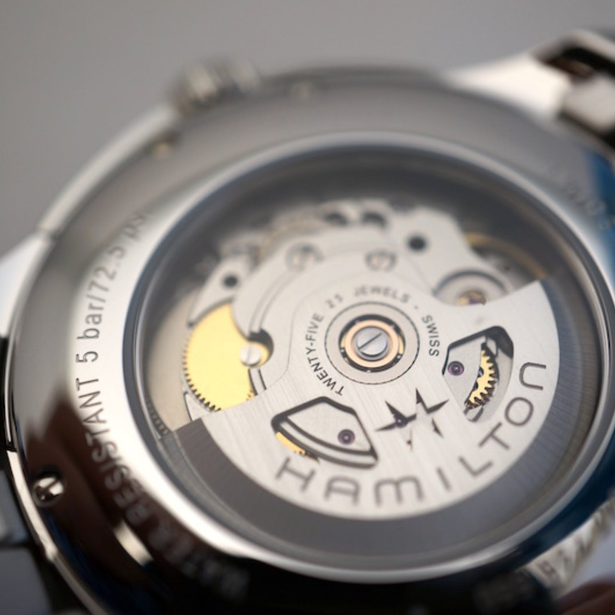 Stainless steel watch case back with visible automatic movement