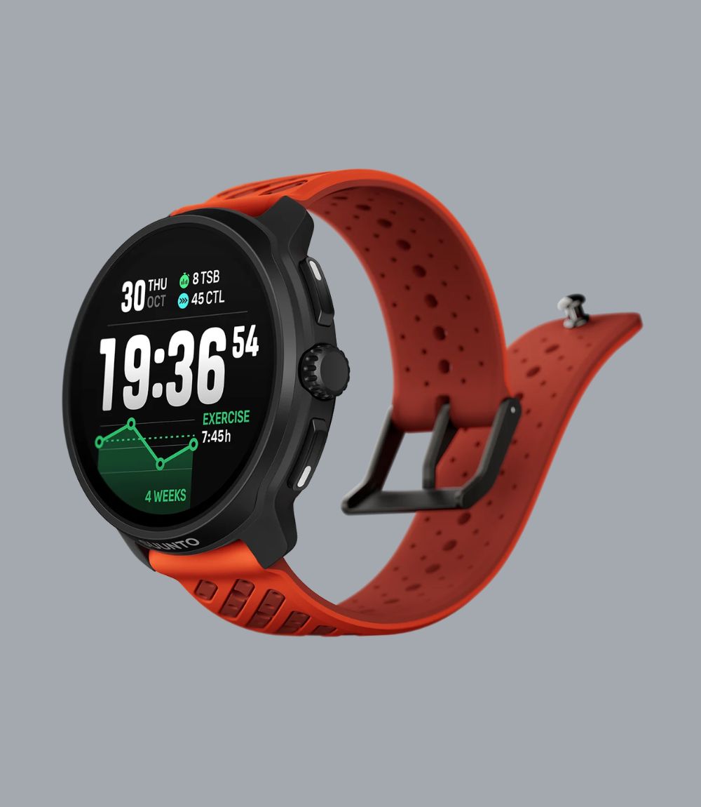 Suunto smartwatch with a black round case and a bright orange perforated silicone strap, showing a digital exercise display