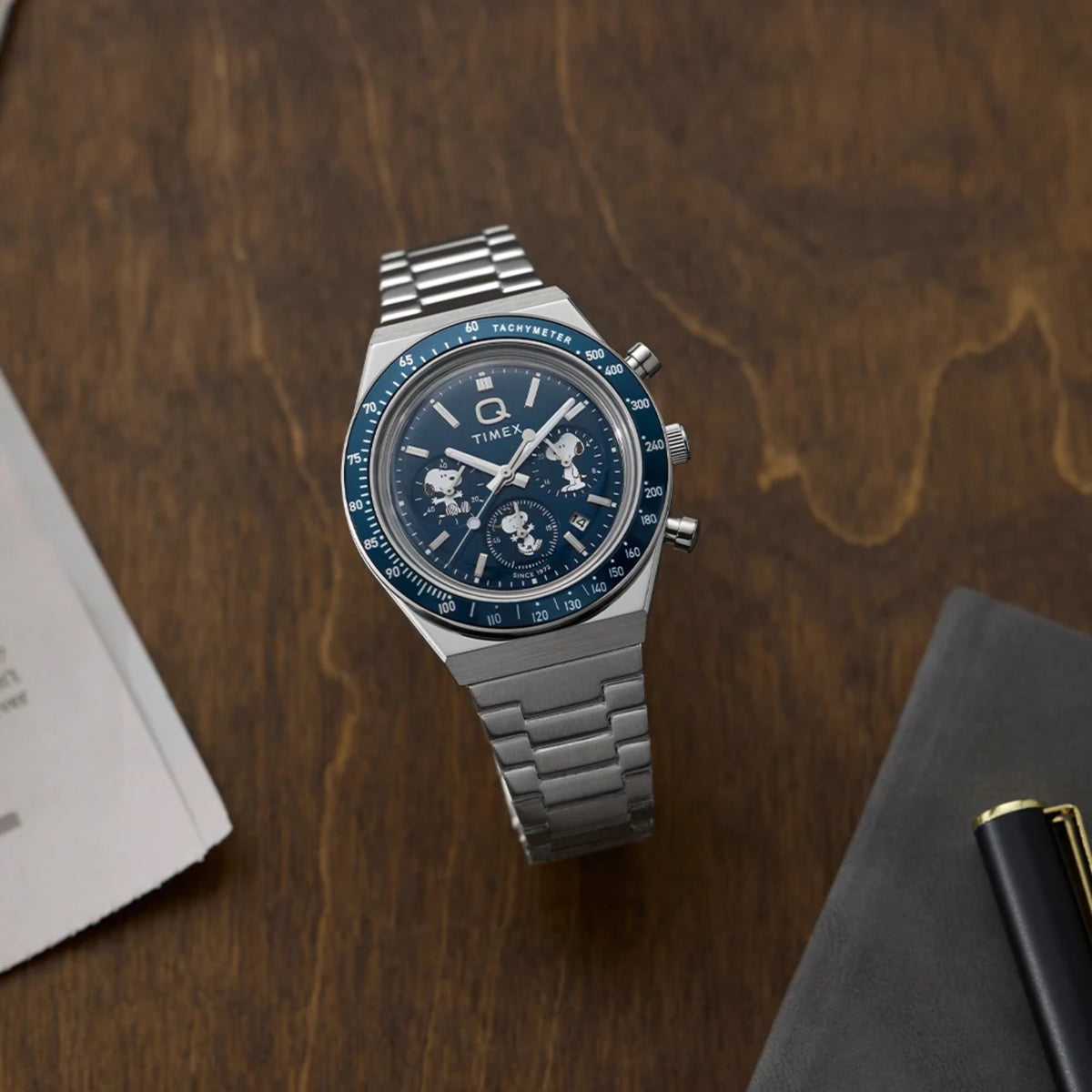 Timex Peanuts TW2Y45300 angled view showcasing blue dial chronograph rested on a wooden surface