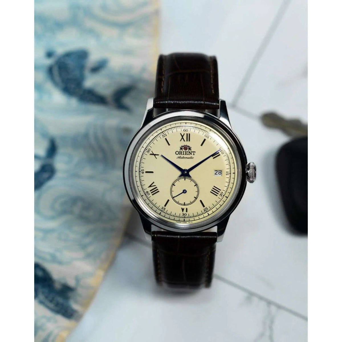 Orient Bambino 38mm Small Seconds RA-AP0105Y30B automatic watch with champagne dial resting upright on a light surface