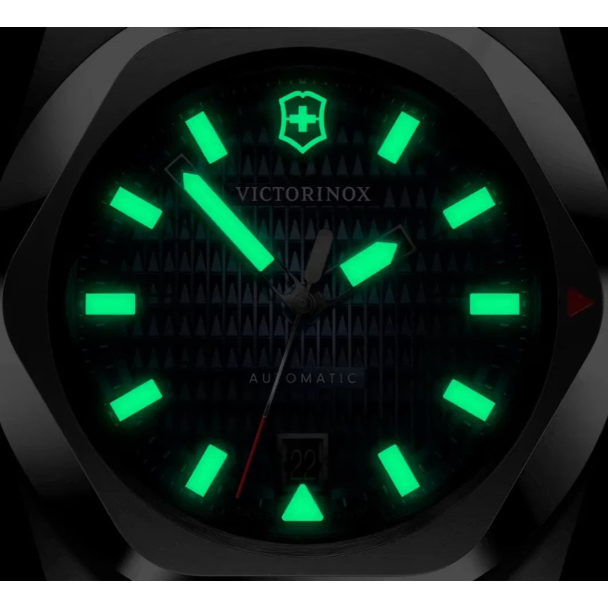 A dark close-up shot of a Victorinox watch featuring green glowing lume