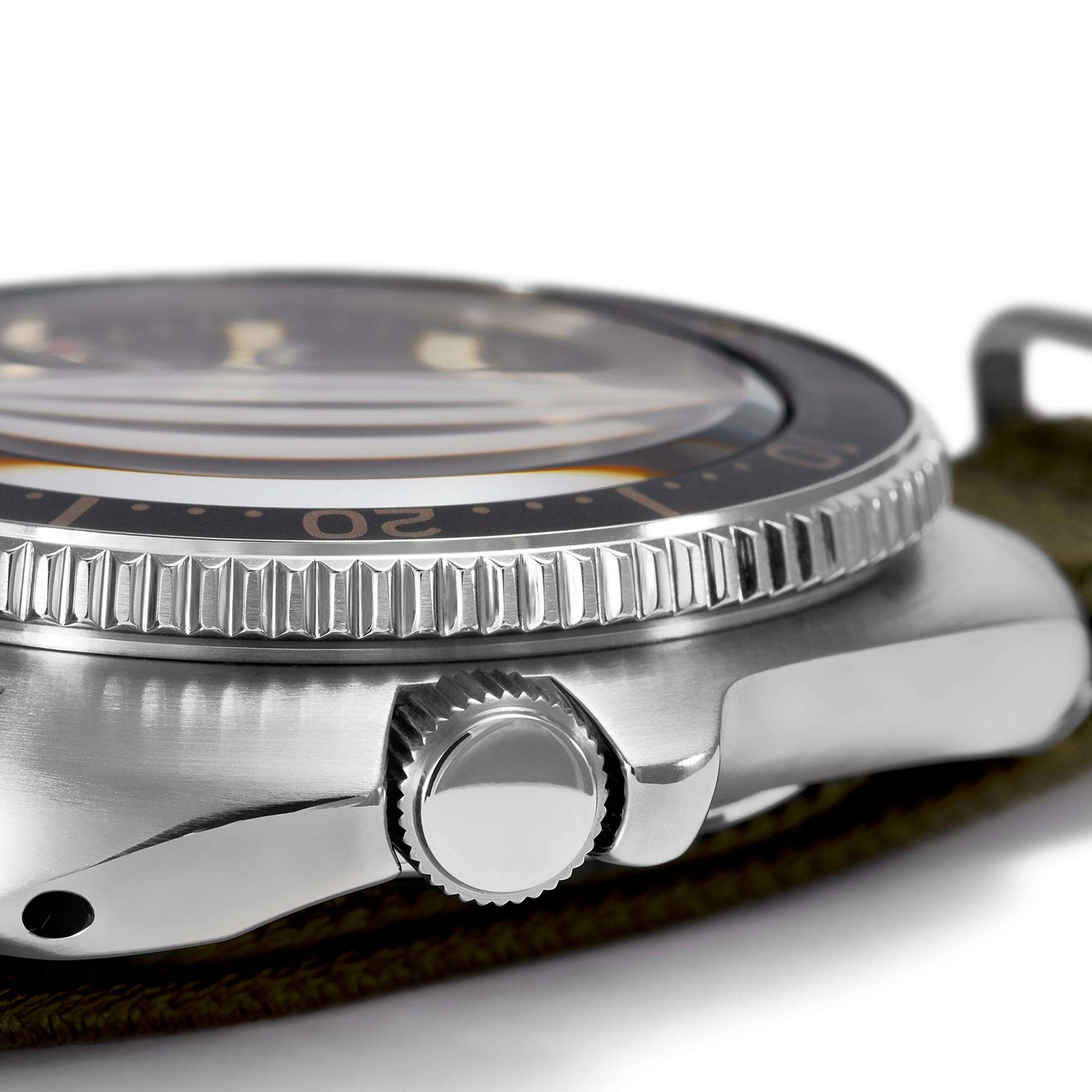 Close-up of a silver wristwatch with a detailed bezel on a white background