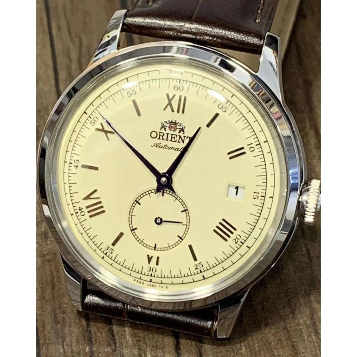 Close-up of the champagne dial, blue hands, Roman numeral markers, and small seconds sub-dial on the Orient Bambino 38mm RA-AP0105Y30B