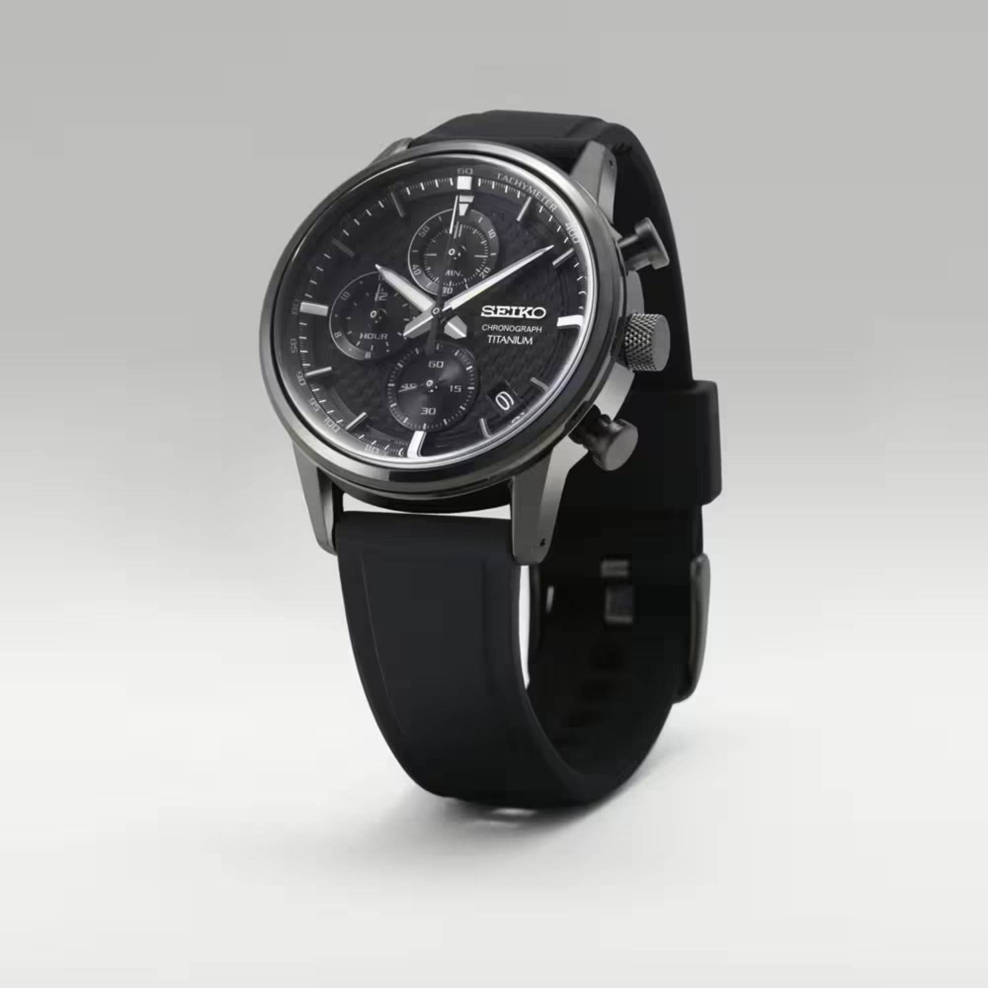 Black Seiko watch with a detailed face on a light gray background