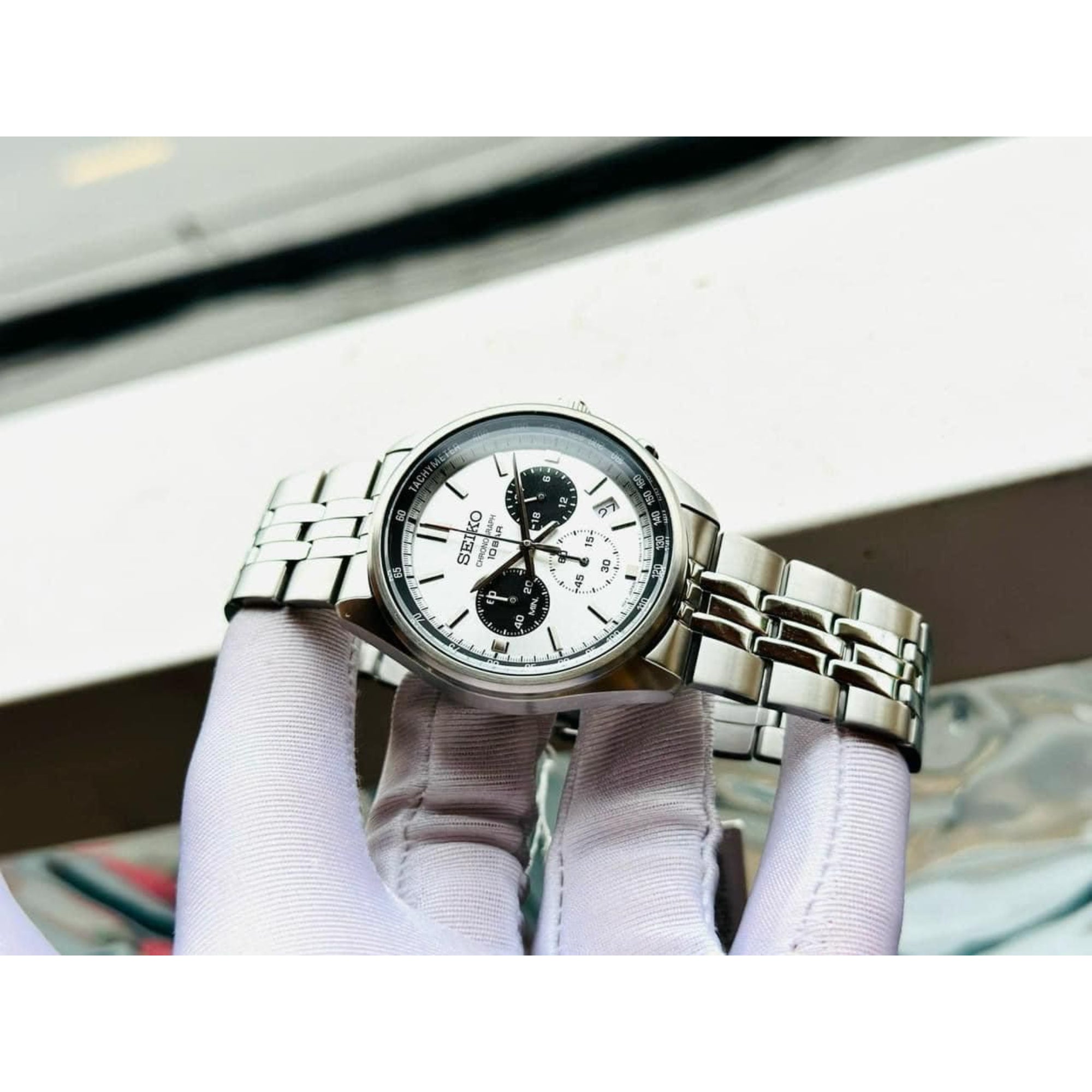 Seiko SSB425P1 panda dial chronograph watch held by gloved hand