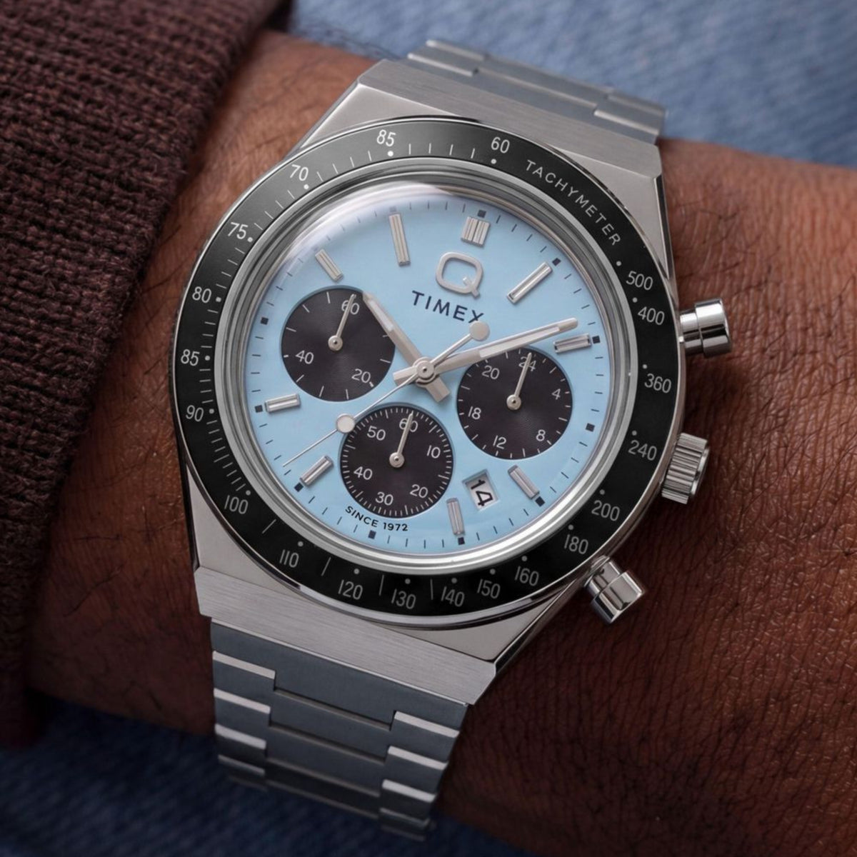 Timex Q TW2Y88600 wrist view showing blue dial chronograph watch styled on a person wearing a steel bracelet