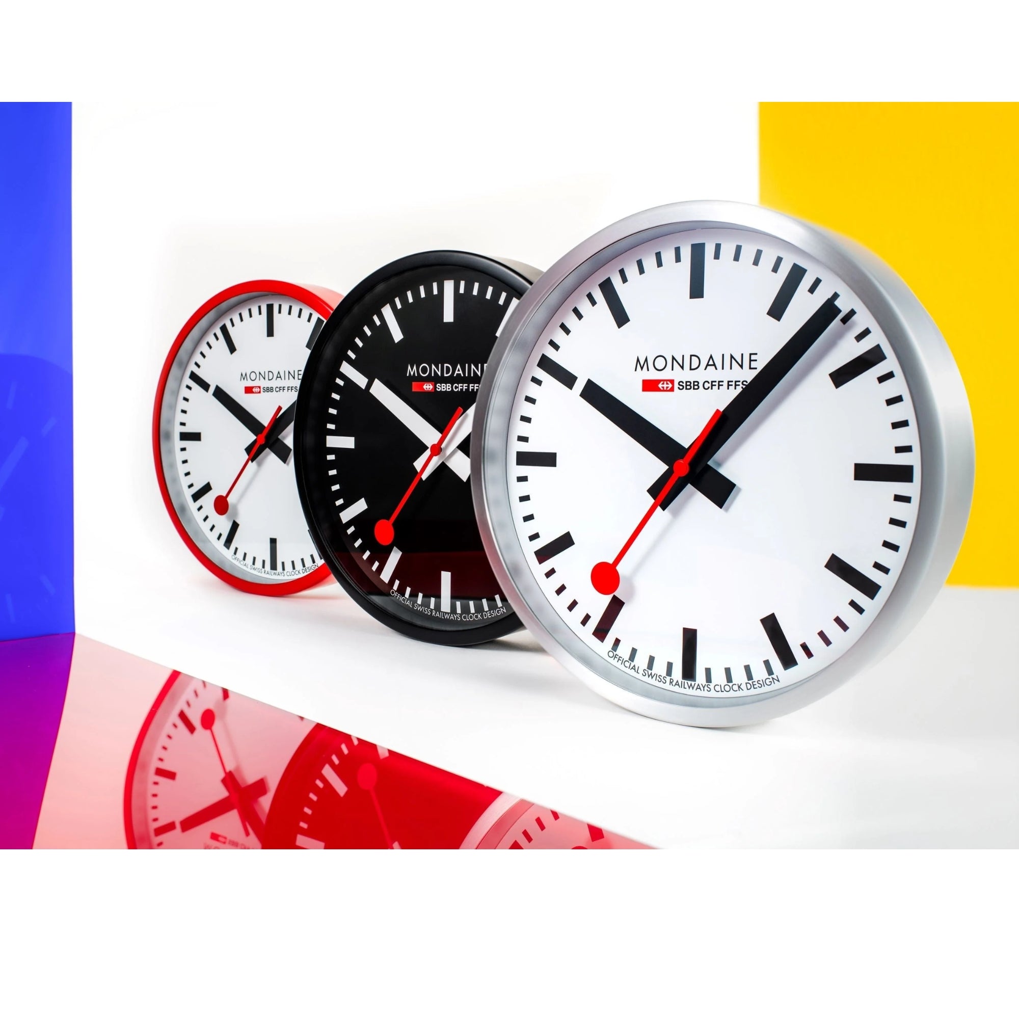Mondaine wall clocks collection displayed in red, black, and silver aluminum cases