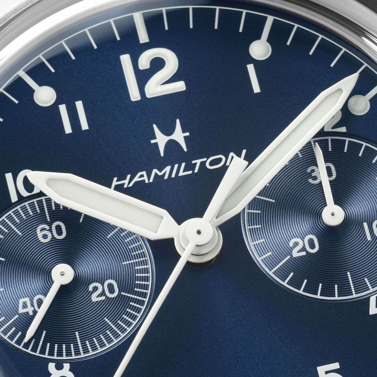 Close-up of a blue Hamilton Khaki Aviation watch dial with two textured sub-dials and white syringe-style hands