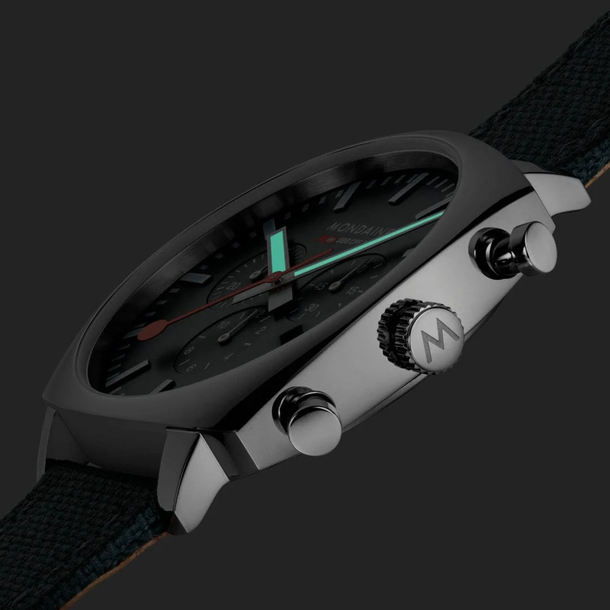 Mondaine Cushion MSL.41460.LF.SET side angle in low light showing luminous hour hands and textured crown
