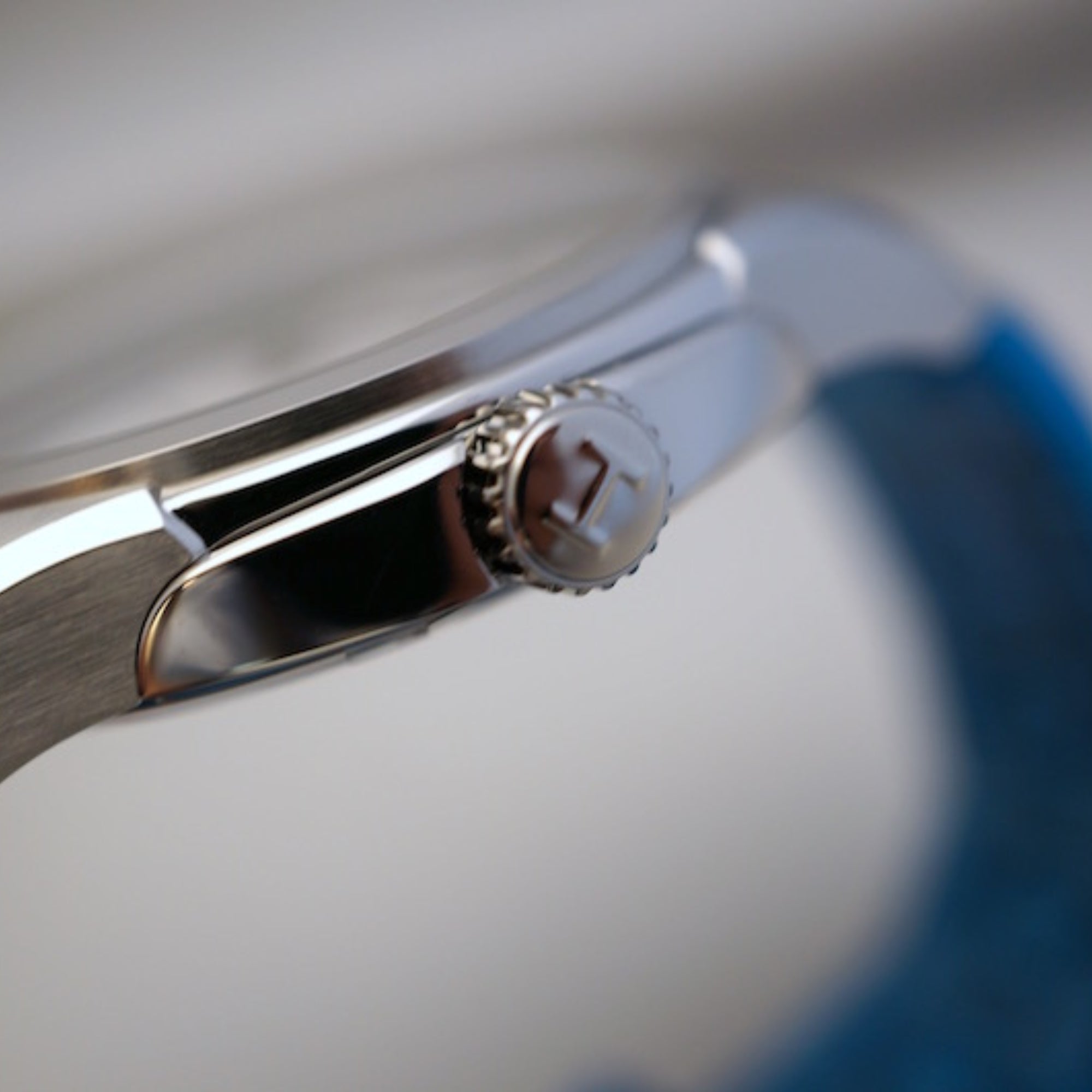 Silver steel men's automatic watch crown detail and polished case side