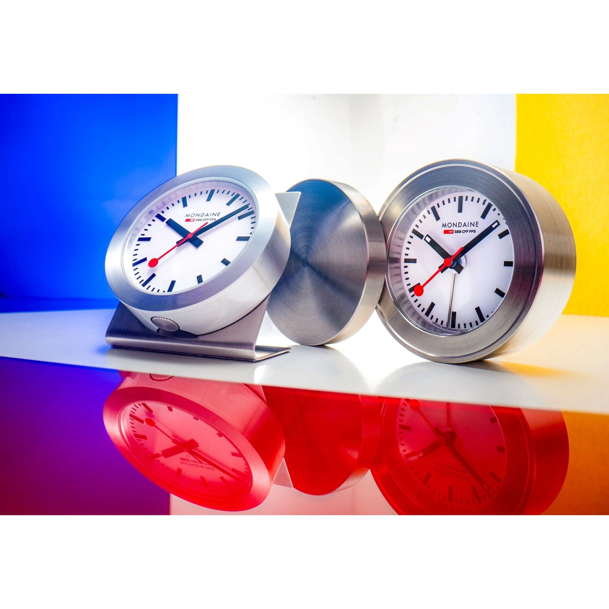 Mondaine Magnet Clock A660.30318.81SBB displayed in a table stand and standalone magnetic case options