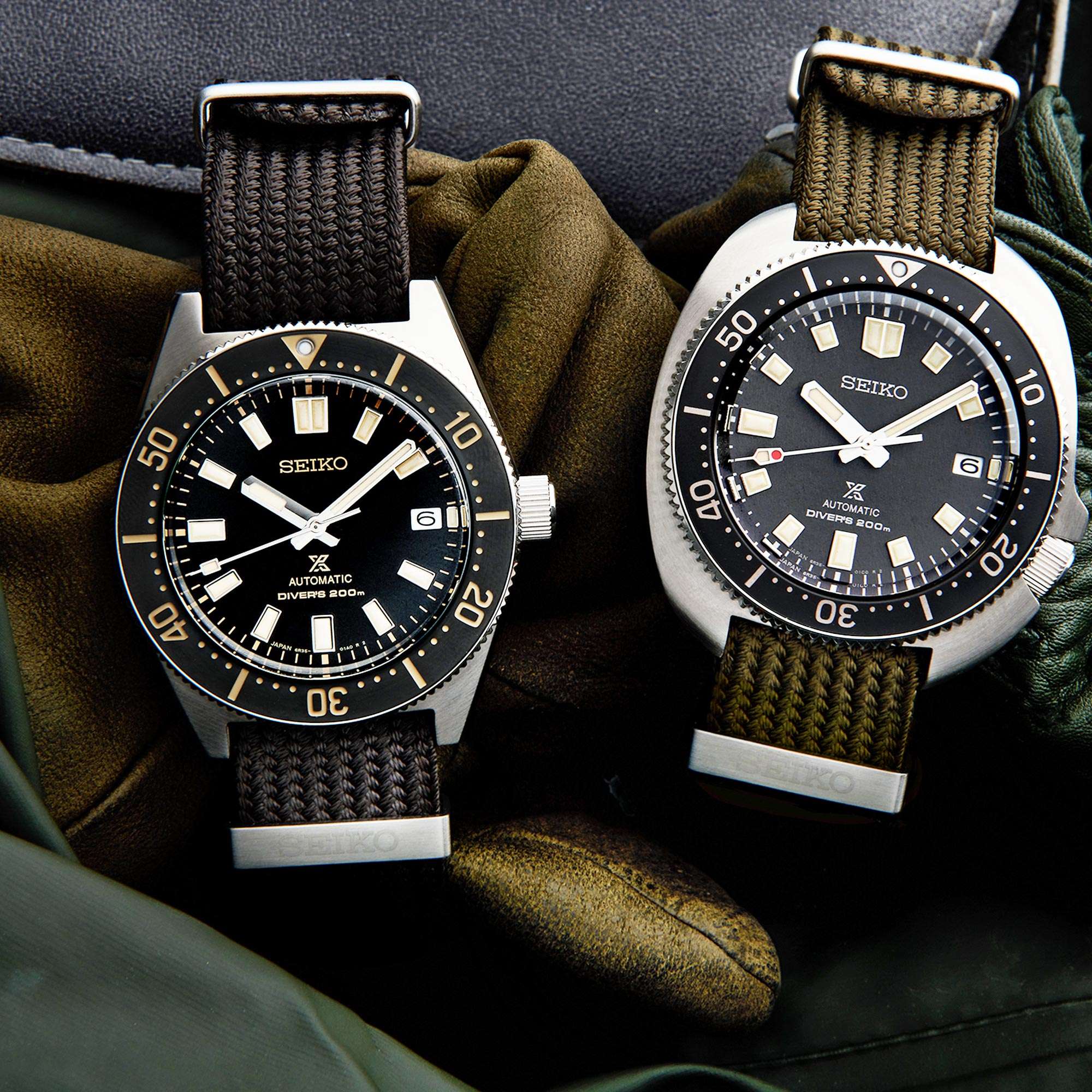 Two Seiko watches with black faces and brown straps on a textured surface.