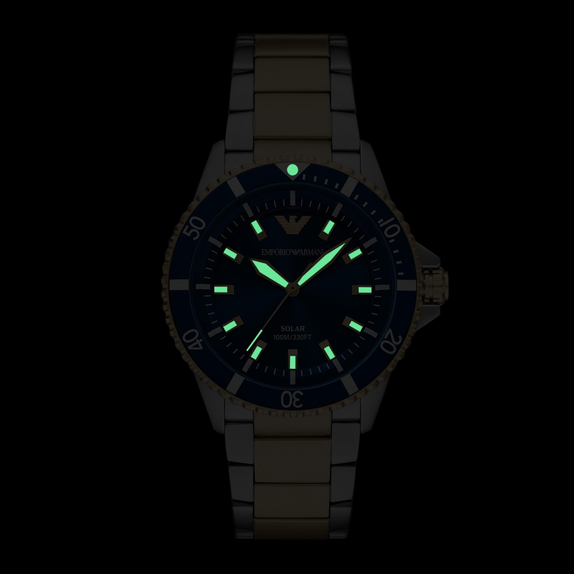 Solar watch with glowing green indices on blue dial, two-tone steel case