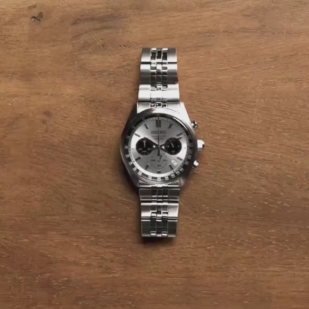 Seiko SSB425P1 panda dial chronograph with stainless steel bracelet front view on a wooden surface